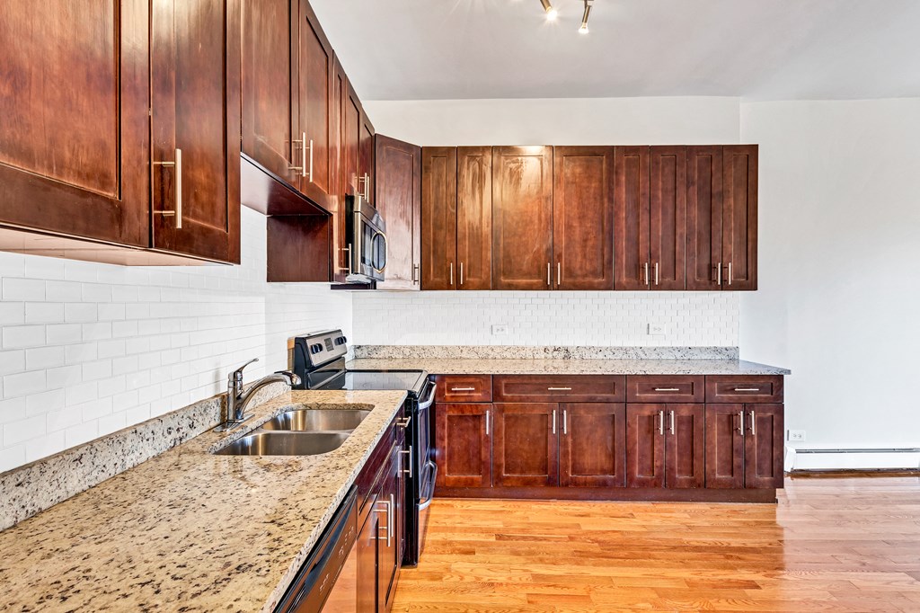 a kitchen with wooden cabinets and granite counter tops and a sink