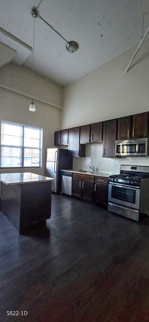 A kitchen with a stove top oven and a refrigerator.