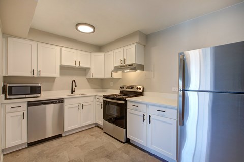 A kitchen with white cabinets and stainless steel appliances.