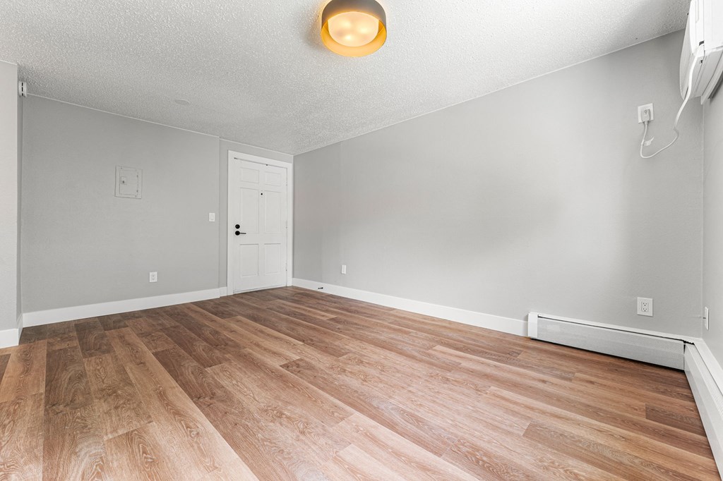 a bedroom with hardwood floors and grey walls