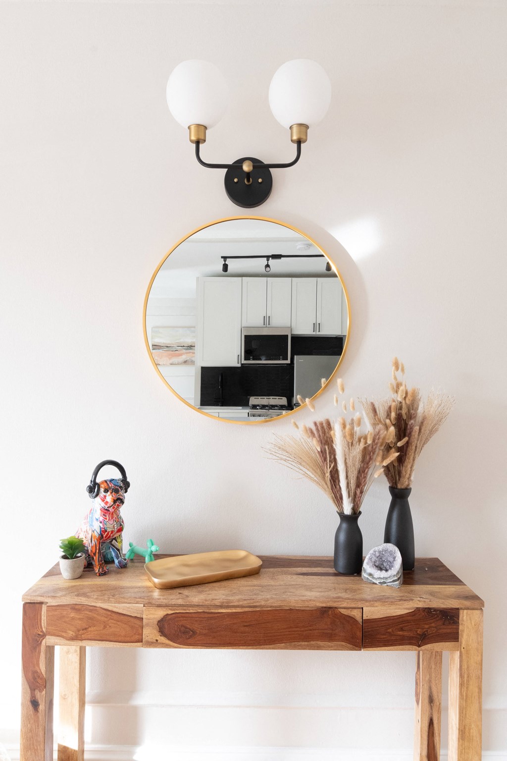 a wooden desk with a mirror and a mirror hanging above it