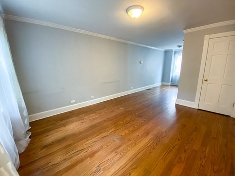 a living room with wooden floors and a white door