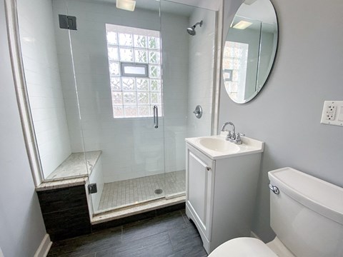 a bathroom with a shower and a sink and a toilet