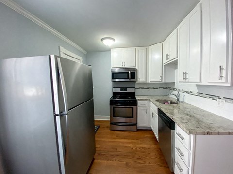 a kitchen with stainless steel appliances and white cabinets