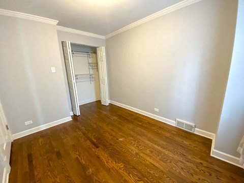 a empty living room with wooden floors and a closet