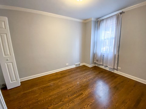an empty living room with wood floors and a window
