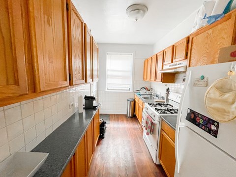 A kitchen with wooden cabinets and a white refrigerator.