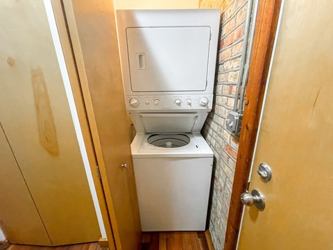 A small white washing machine and dryer in a small room.