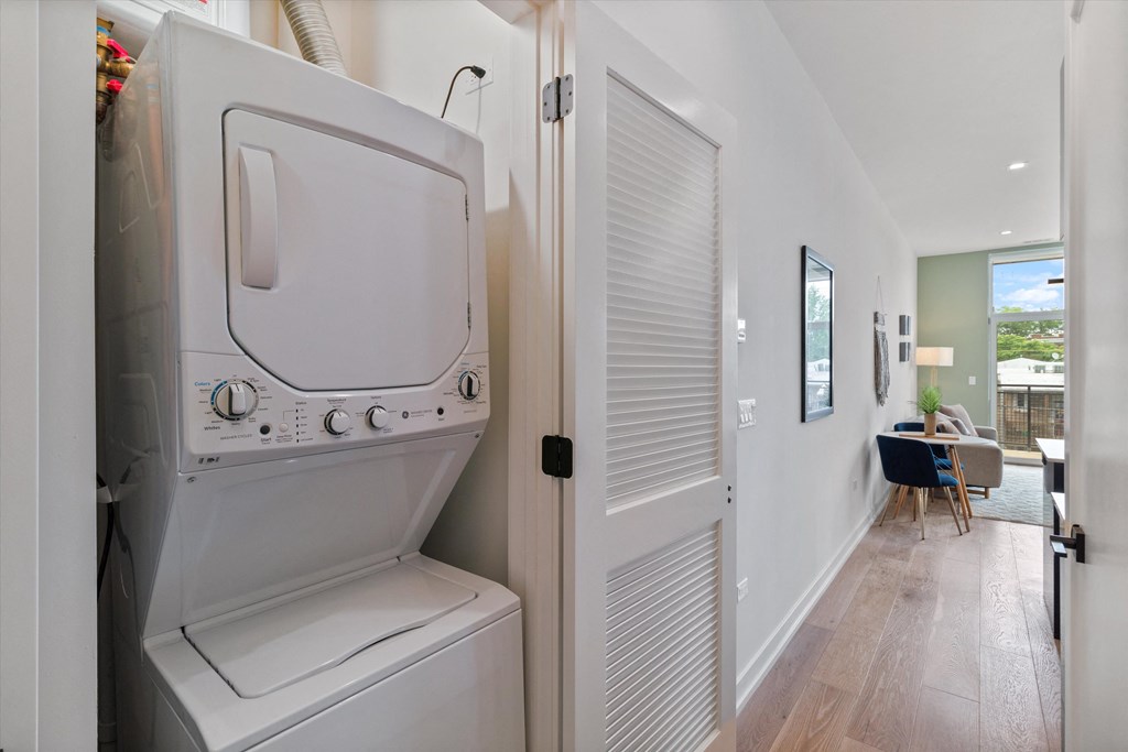 a washer and dryer in a hallway next to a door to a kitchen