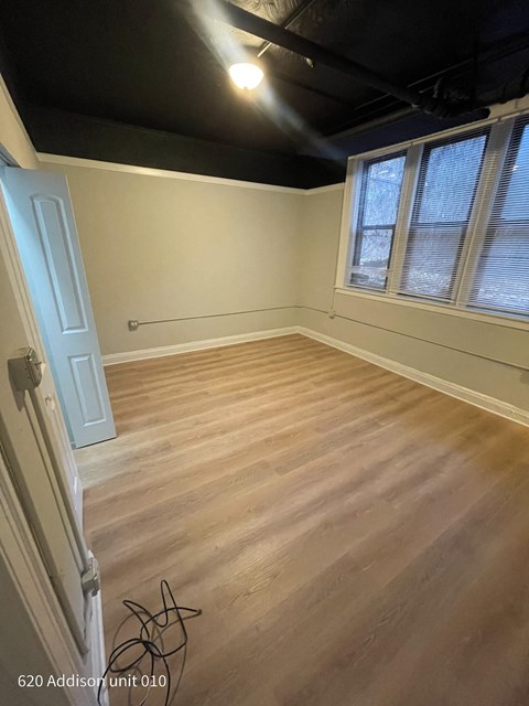 the living room of a house with wooden floors and a black ceiling