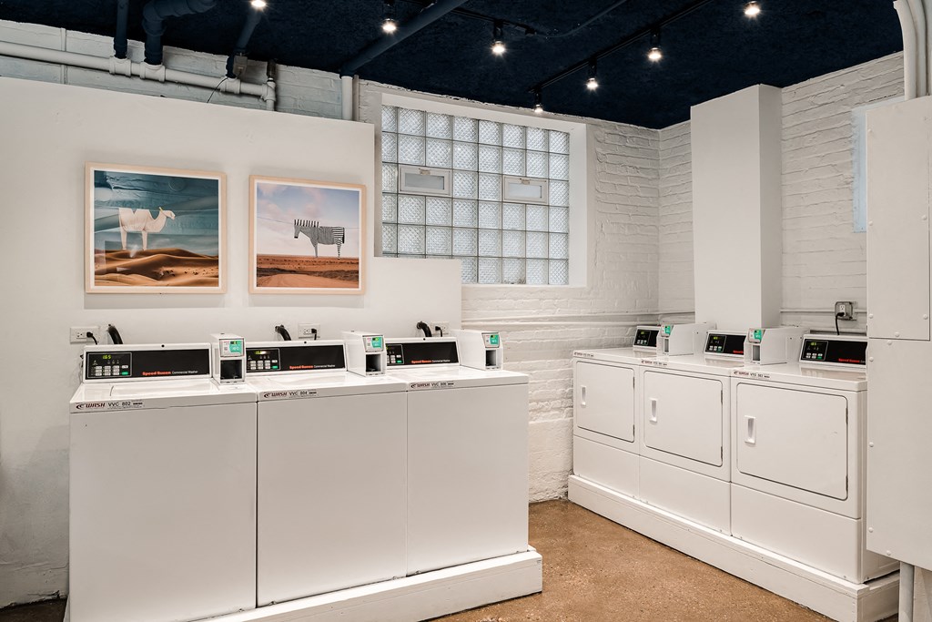 a white kitchen with white appliances and pictures on the wall