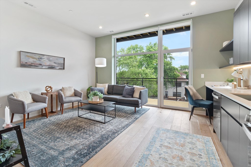 an open living room with a kitchen and a large window