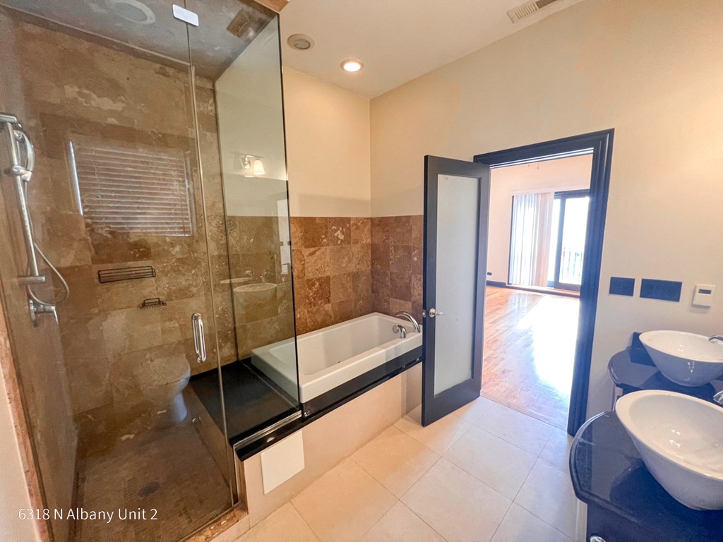 a bathroom with a large shower and a sink and a toilet