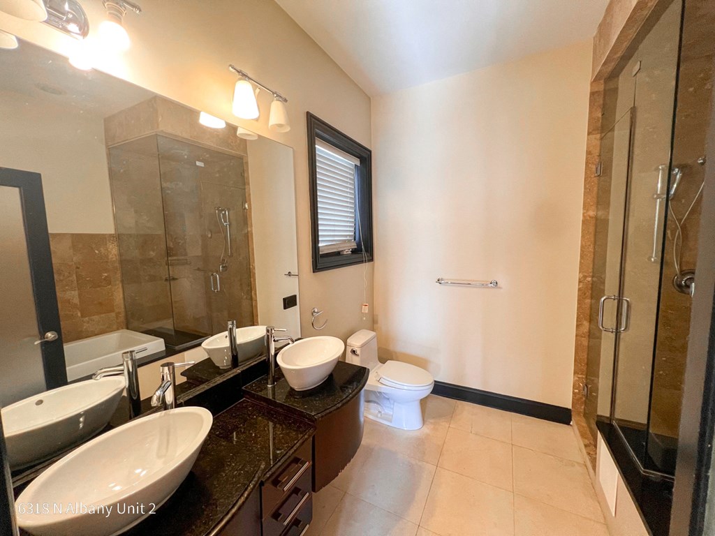 a bathroom with two sinks and a shower and a toilet