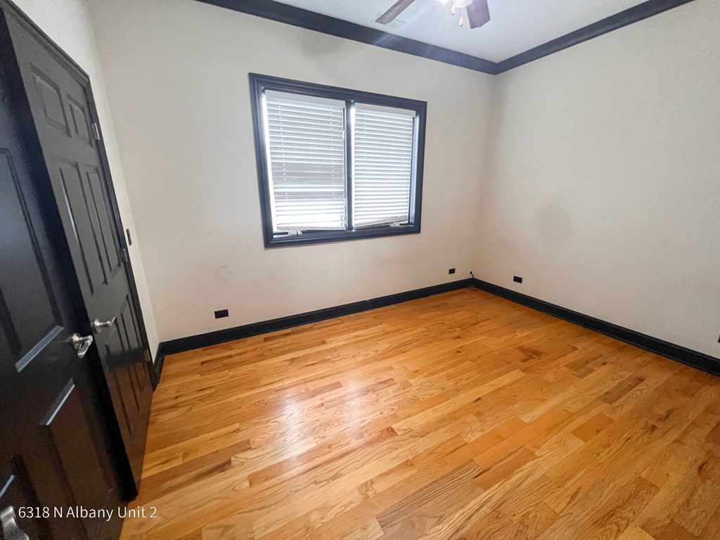 the living room of a house with wood floors and a window