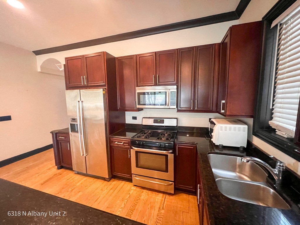 a kitchen with wooden cabinets and stainless steel appliances