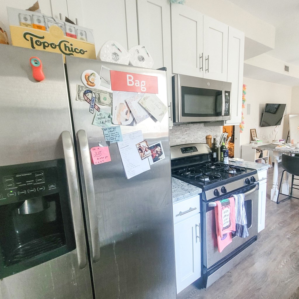 a kitchen with stainless steel appliances and a refrigerator and a stove