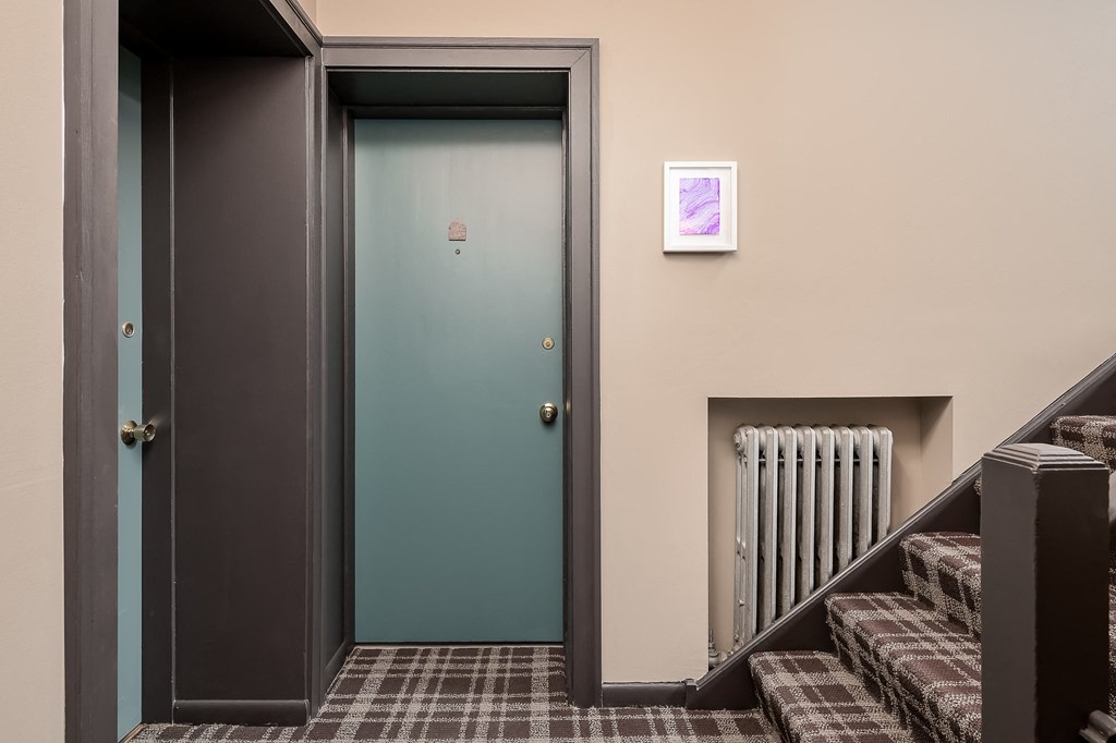 the door to a room with stairs and a green door