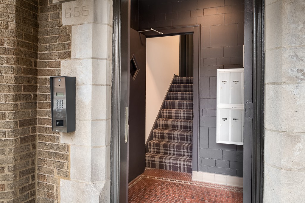the front door of a building with a staircase and a mail box