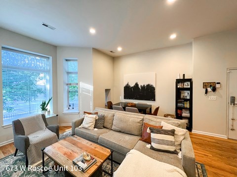 A living room with a grey couch, a chair, and a coffee table.