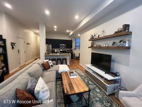 A living room with a grey couch and a wooden coffee table.