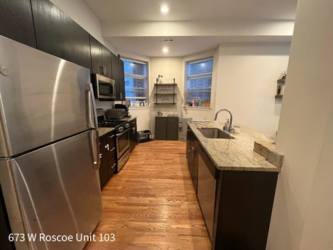 A kitchen with wood floors and stainless steel appliances.