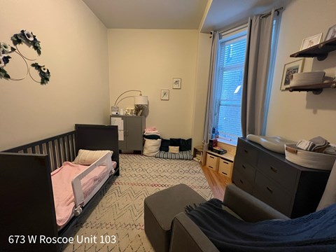 A bedroom with a bed, dresser, and window.
