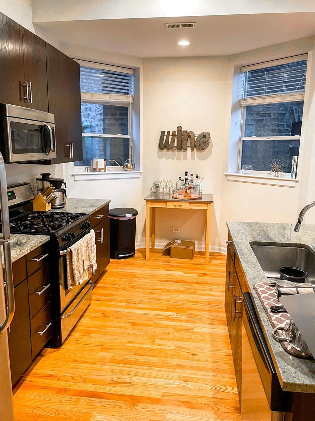 a kitchen with wooden floors and stainless steel appliances