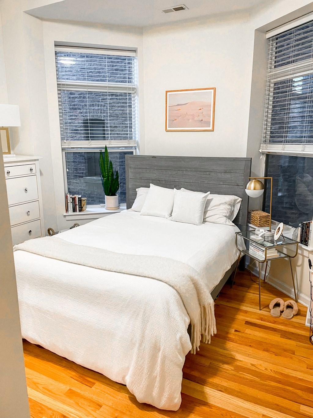 a bedroom with a bed and two windows