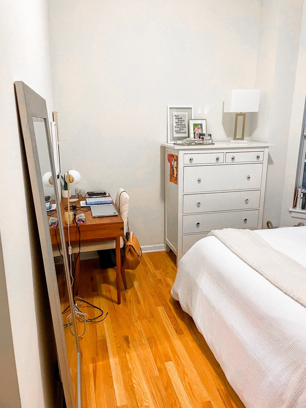 a bedroom with a bed and a desk with a mirror