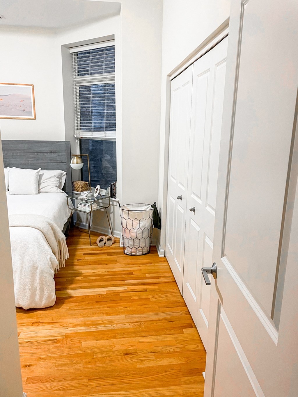 a living room with wooden floors and white cabinets