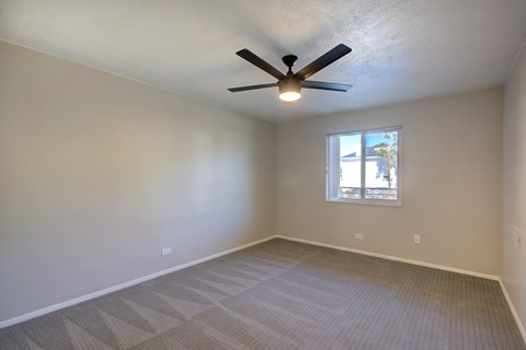 A room with a ceiling fan and a window.