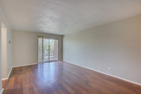 A room with wooden floors and a sliding glass door.