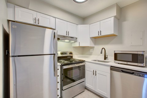 A kitchen with white appliances and cabinets.