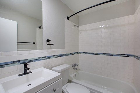 A white bathroom with a white tub and sink.