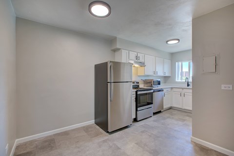 A kitchen with a refrigerator, oven, and microwave.