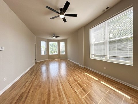 A room with wooden flooring and a ceiling fan.