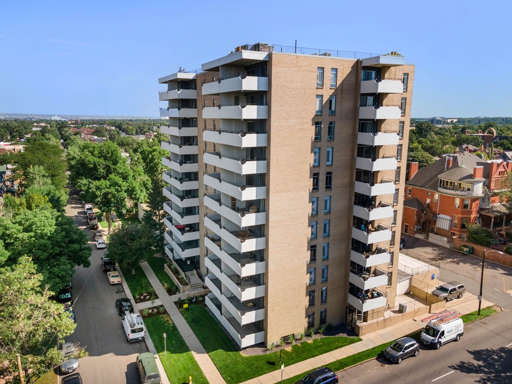 an aerial view of an apartment building with cars parked in front
