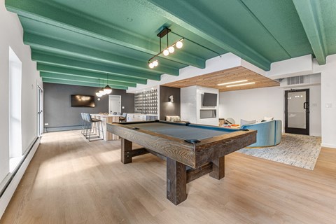 a pool table in a living room with a blue ceiling
