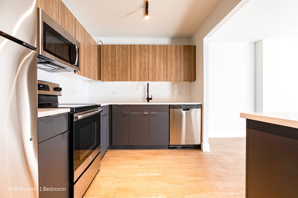 an empty kitchen with black appliances and wooden cabinets