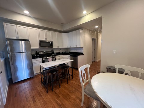 A kitchen with a table and chairs.