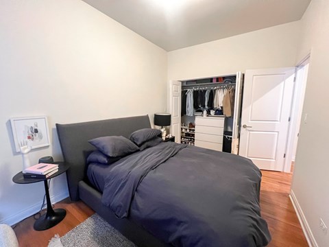 A bedroom with a large bed and a small table with a book on it.