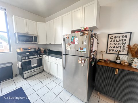 A kitchen with a refrigerator and a sign on the wall.