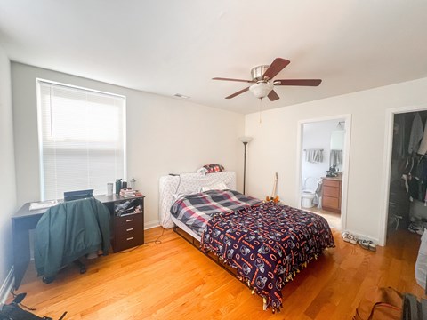A bedroom with a bed, desk, and chair.