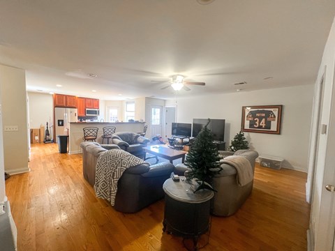 A living room with a couch, chair, and a television.
