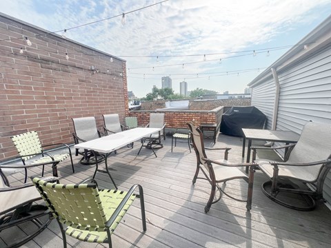 A patio with a table and chairs is set up on a wooden deck.