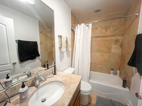 A bathroom with a sink, toilet, and bathtub.