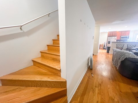 A set of wooden stairs leading to a living room.