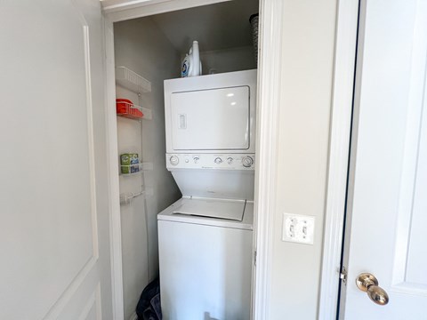 A white washing machine is in a small space in a home.