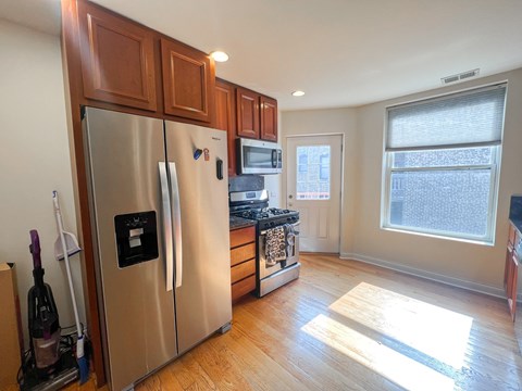 A kitchen with wooden cabinets and a stainless steel refrigerator.